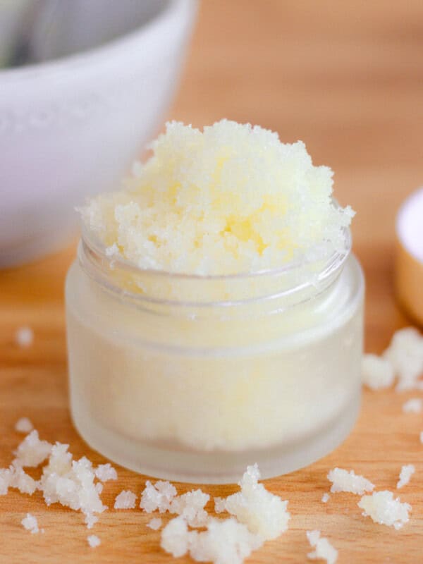 Homemade sugar scrub in glass jar on wooden table.