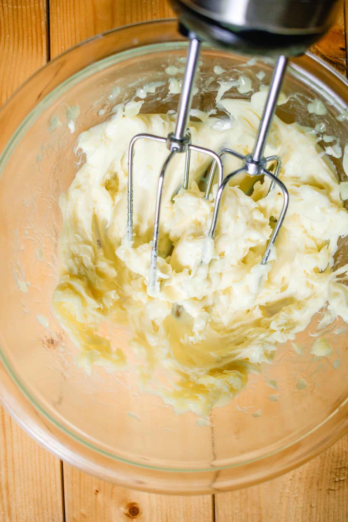 Body butter being whipped with a hand mixer until stiff peaks form.