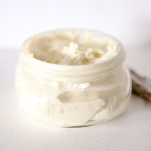 DIY whipped body butter cooling in a glass storage jar.