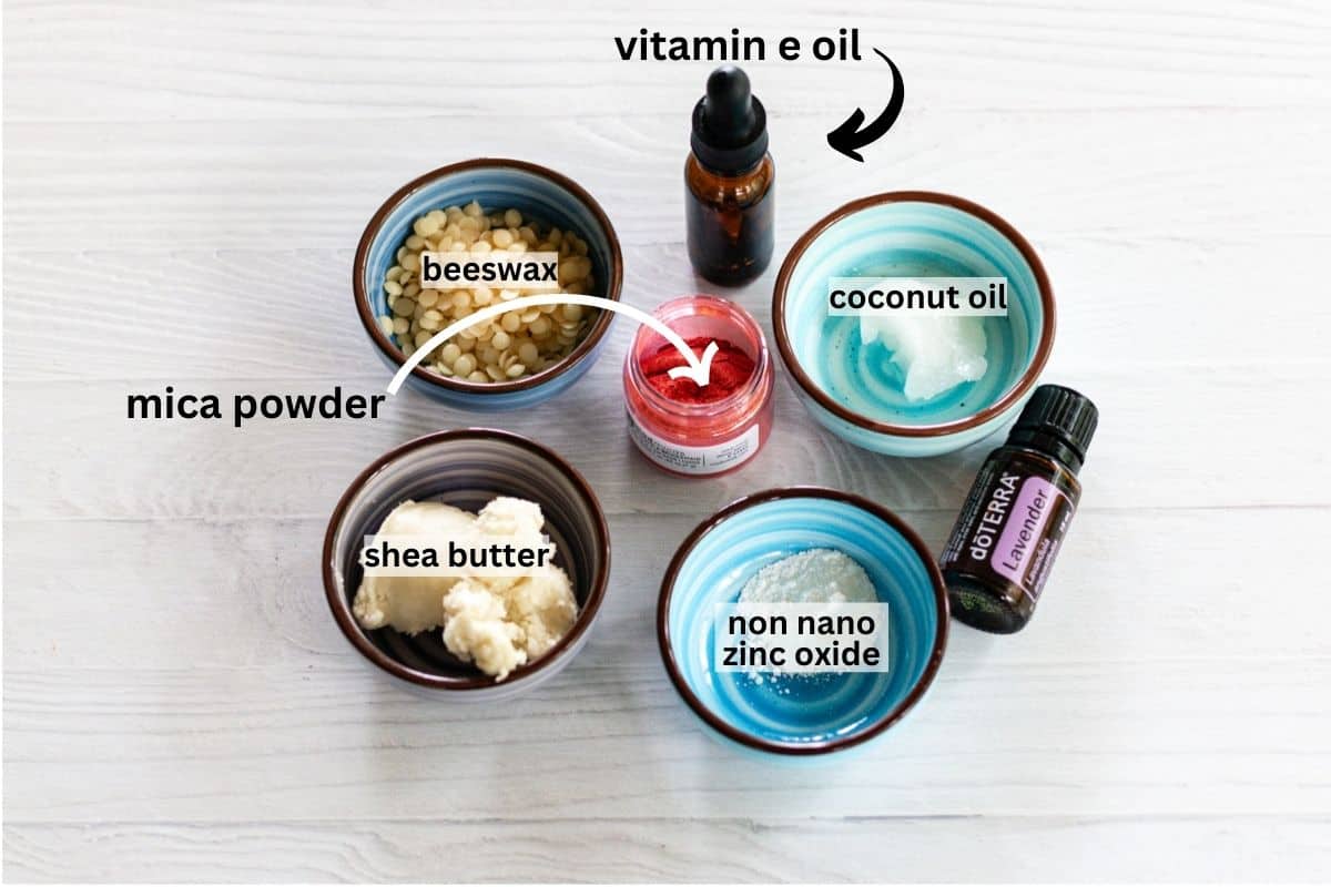 Lipstick ingredients assembled on a wooden countertop.