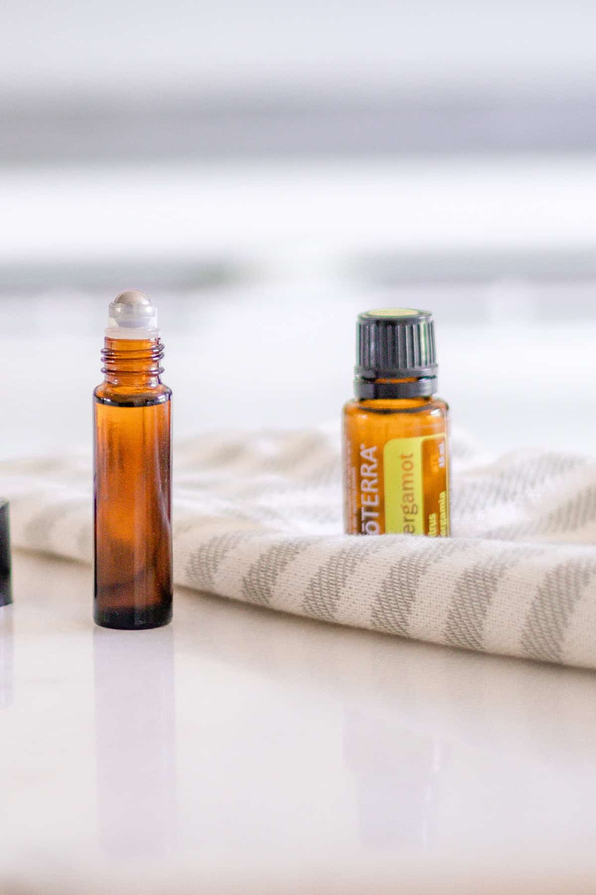 Bergamot essential oil on a white and grey striped tea towel.