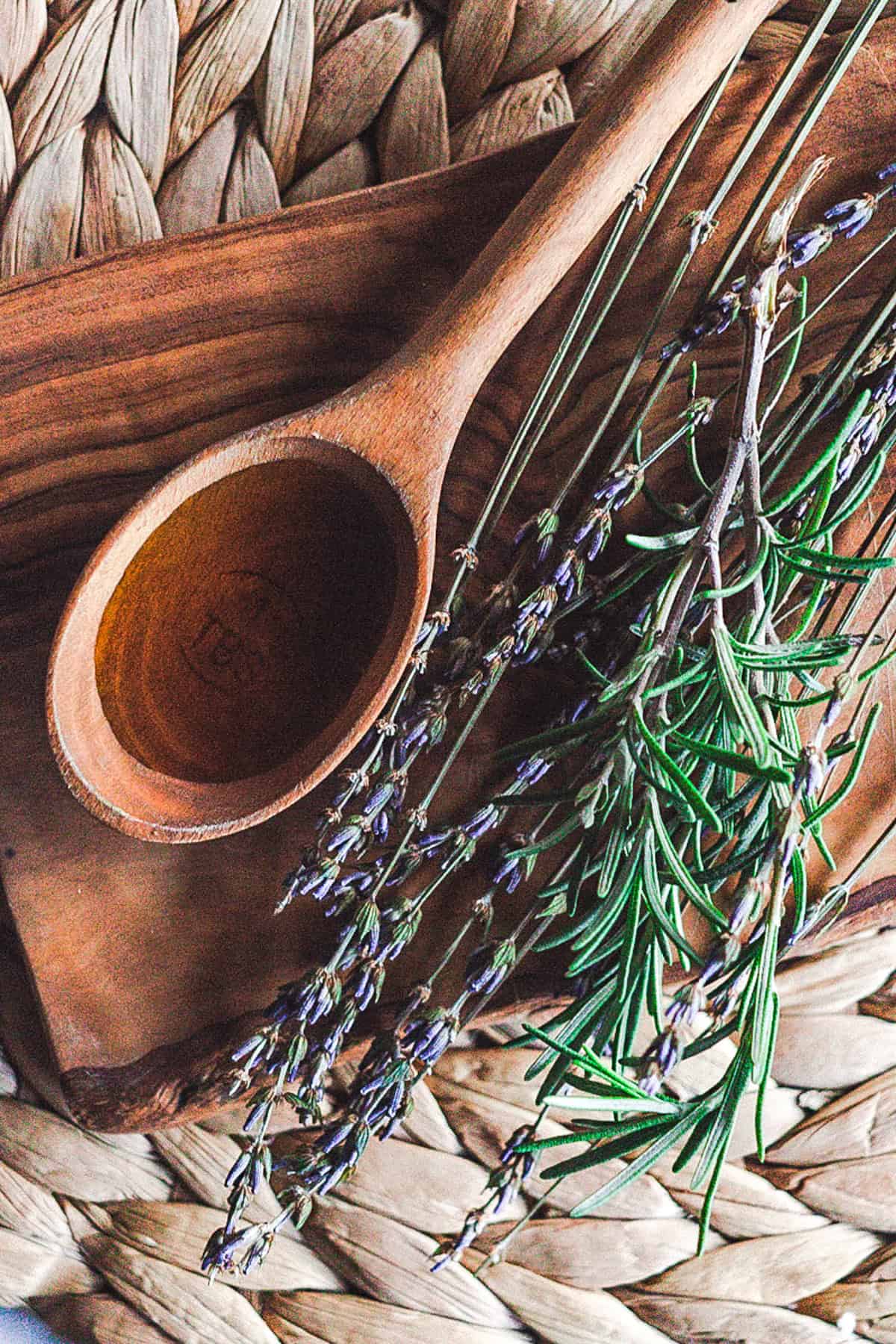 Small wooden spoon of black seed oil on a wooden tray. 