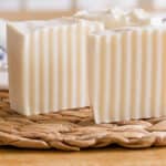 Two cold process shampoo bars standing upright on a wicker mat.