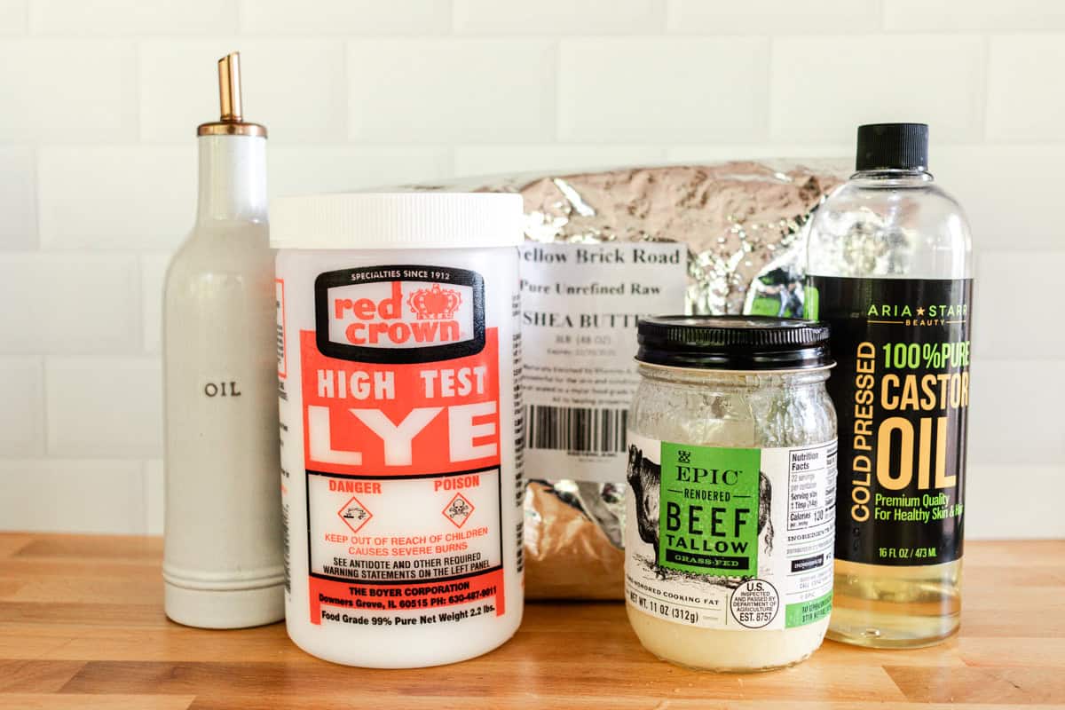 Cold process shampoo bars ingredients lined up on a wooden countertop.