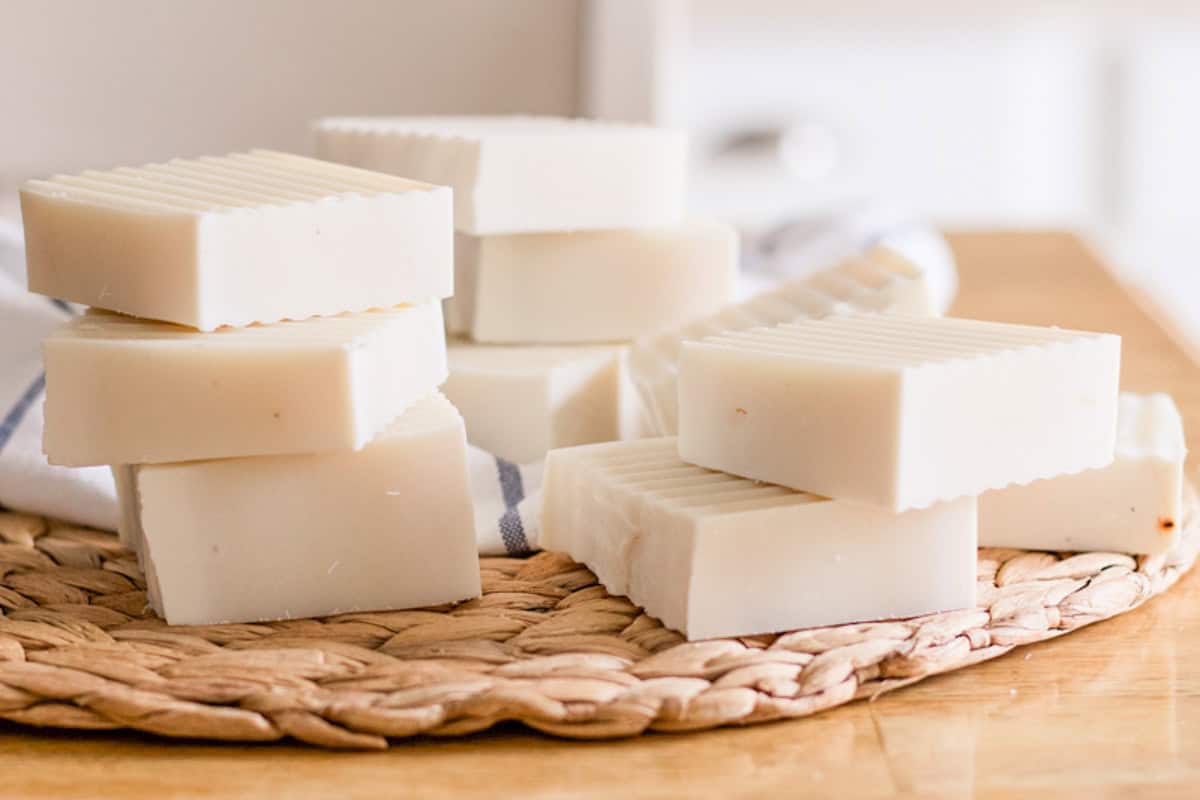Stacks of cold process shampoo bars on a wicker placemat.