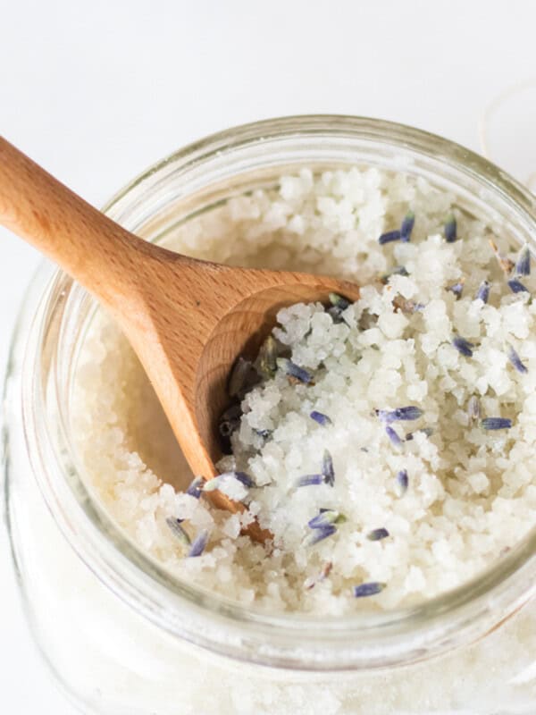 A jar of detoxifying foot bath with a wooden spoon sticking out of it.