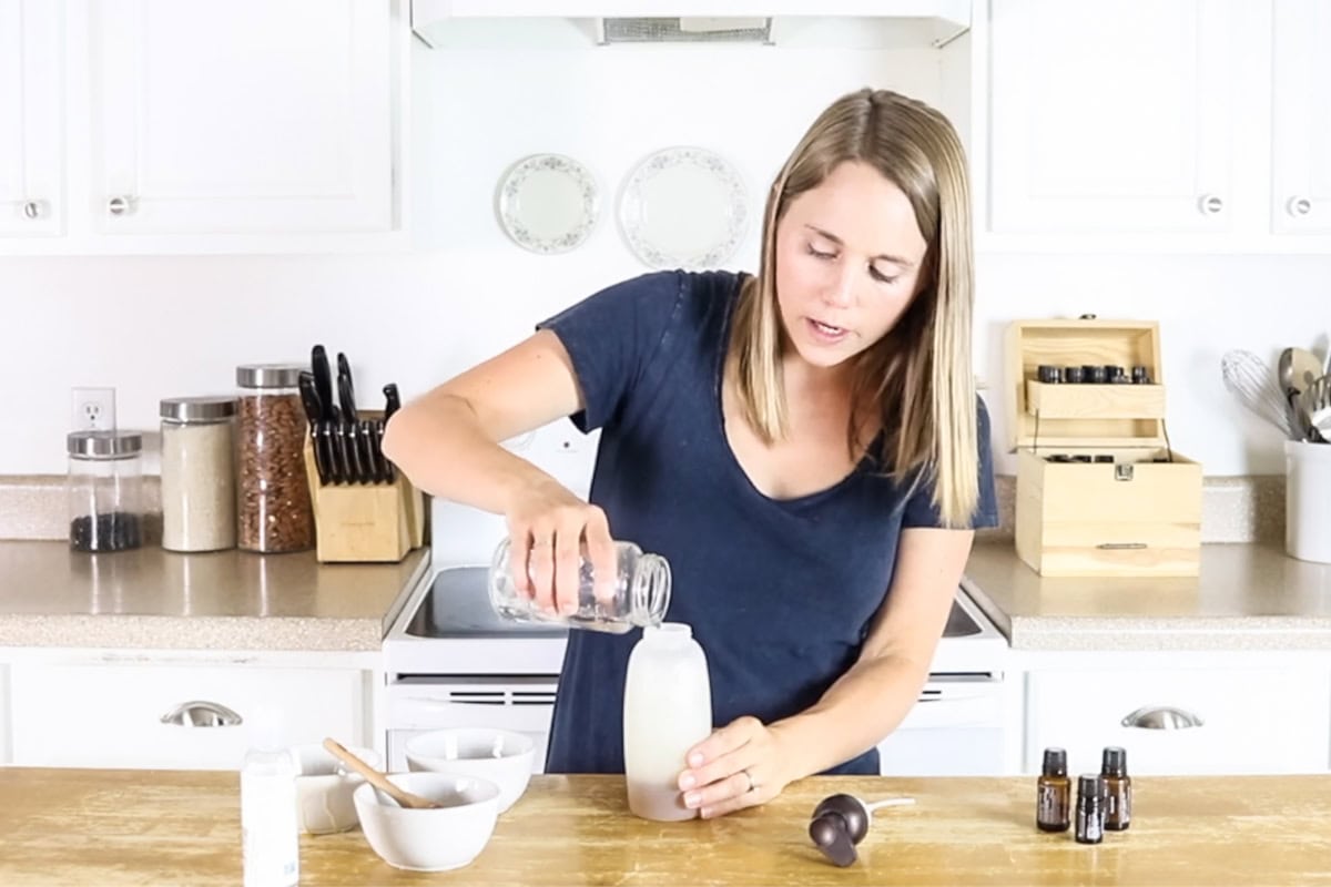Pouring water into a foaming soap bottle to make natural body wash.