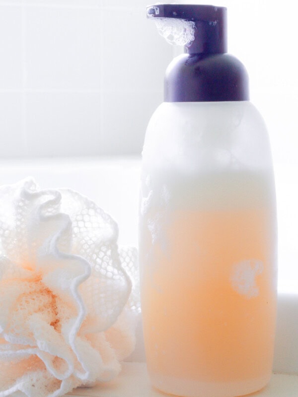A bottle of natural body wash with a loofah.