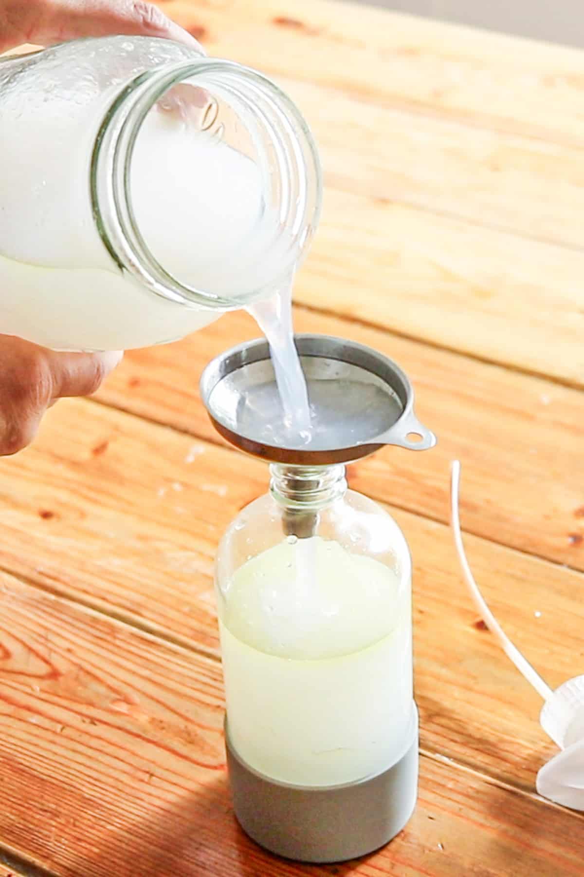 Transfering the bug spray for plants from the bulk jar to a smaller spray bottle.