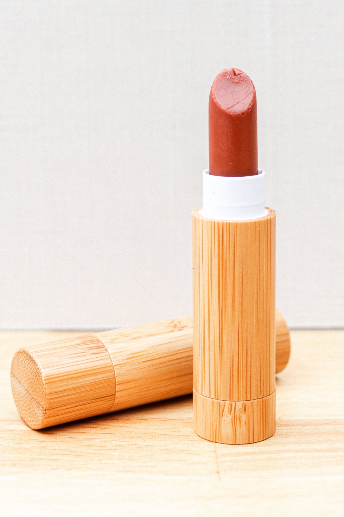 A tube of homemade lipstick on a wooden countertop.