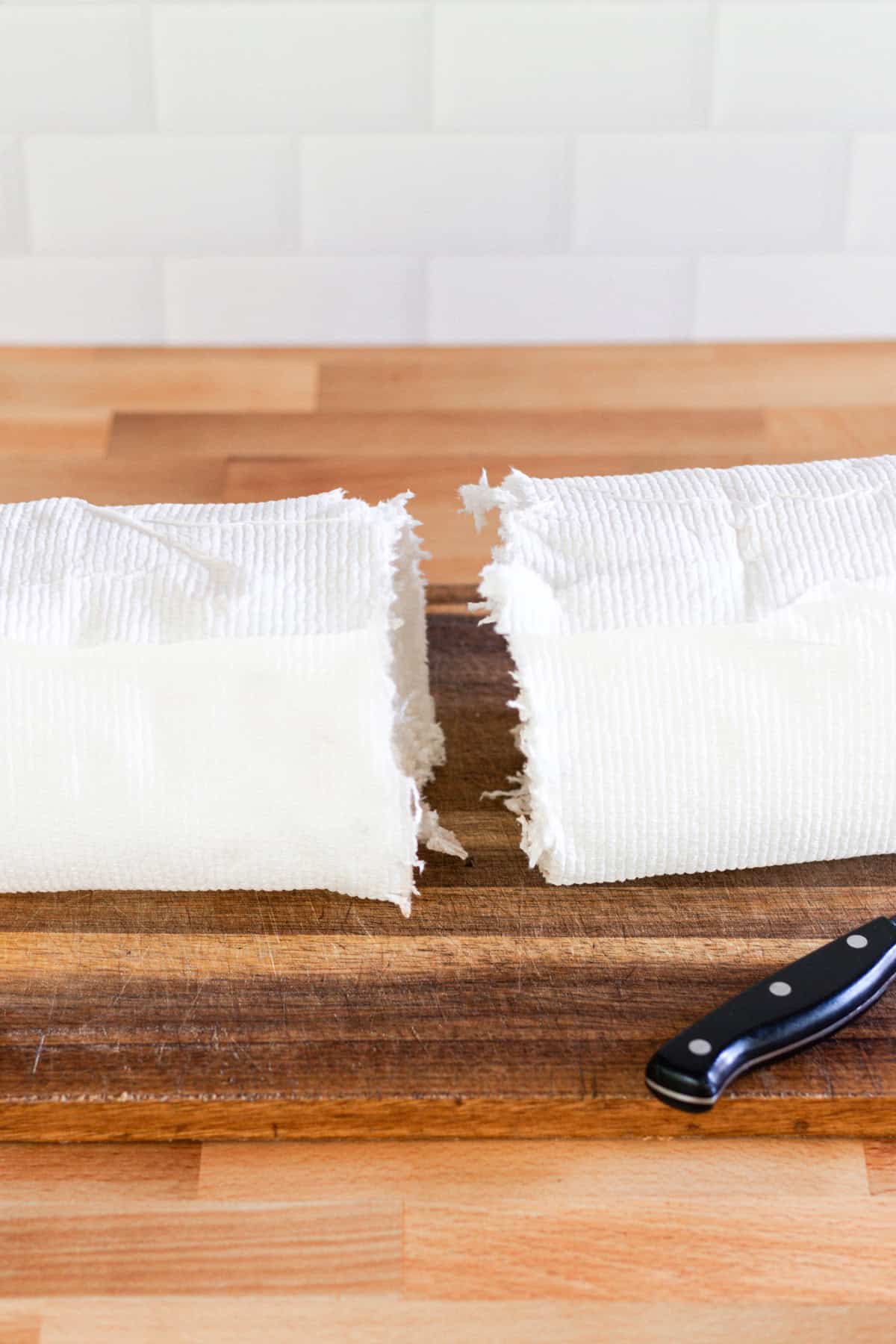 A roll of paper towels that has been cut in half with a knife.