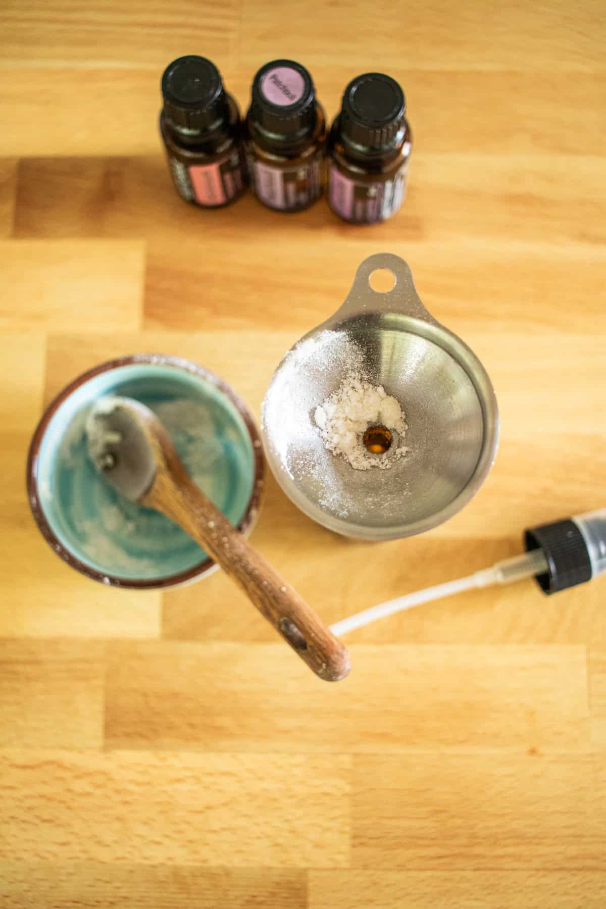 An empty bowl with a spoon in it and a funnel with baking soda in it.