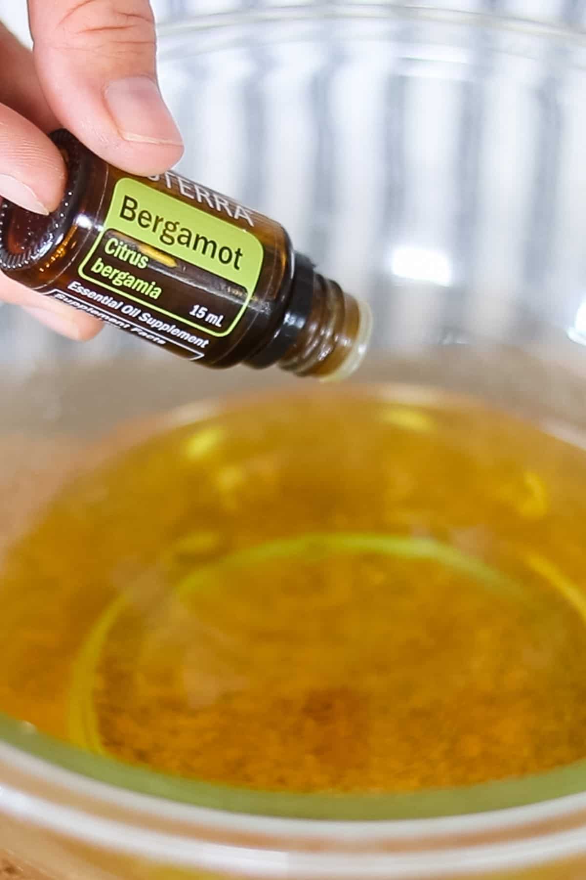 Adding essential oils to the melted wax mixture.