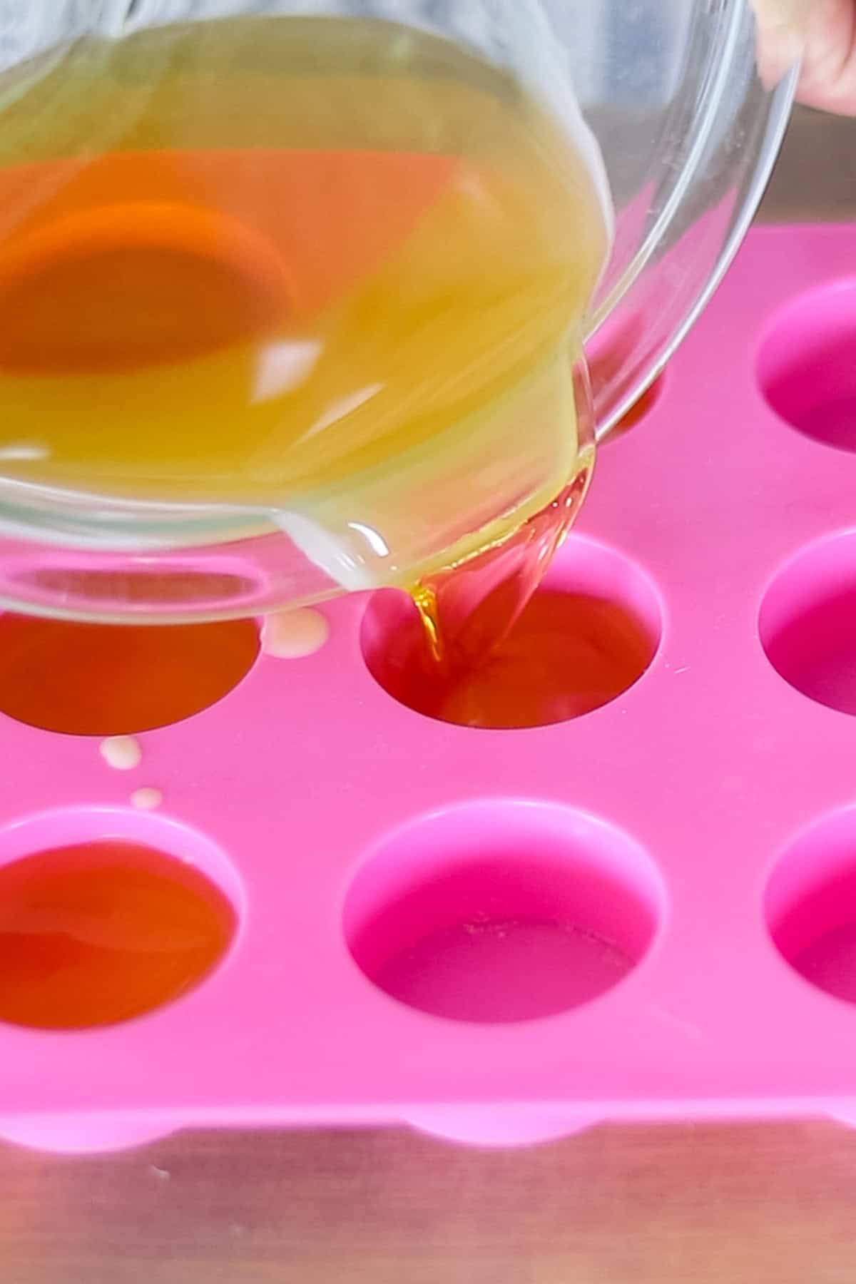 Pouring melted wax mixture into silicone molds. 