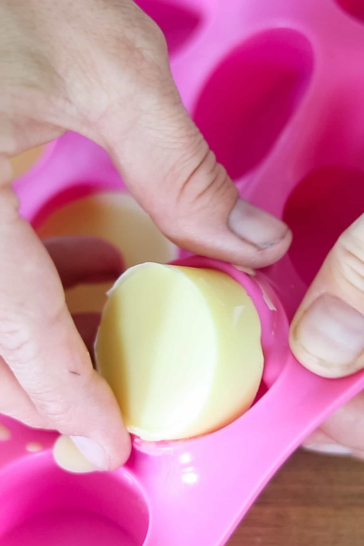 Removing the cooled wax melts from the silicone mold.