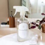 Homemade window cleaner sitting on a white marble vanity.