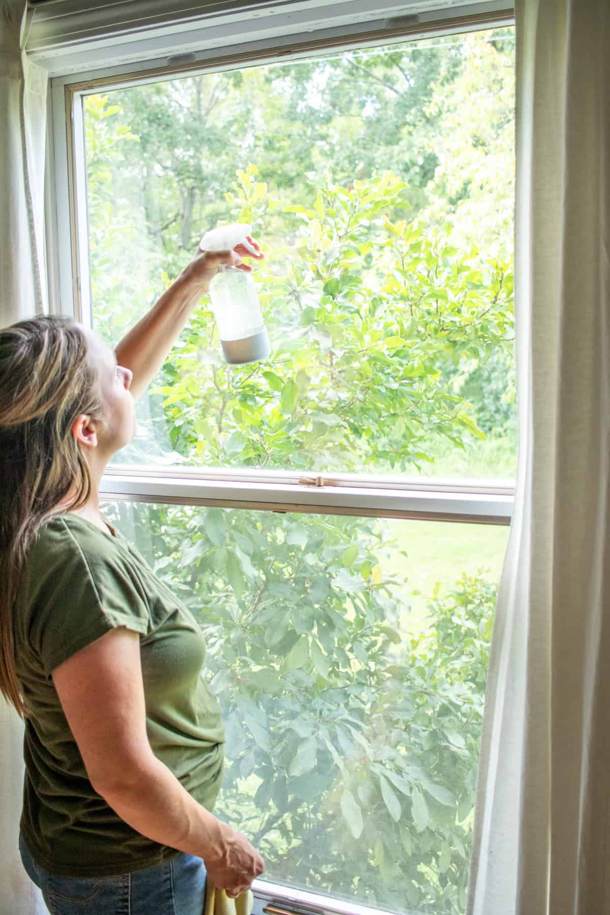 Spraying the window, from the top down with my homemade cleaning solution.