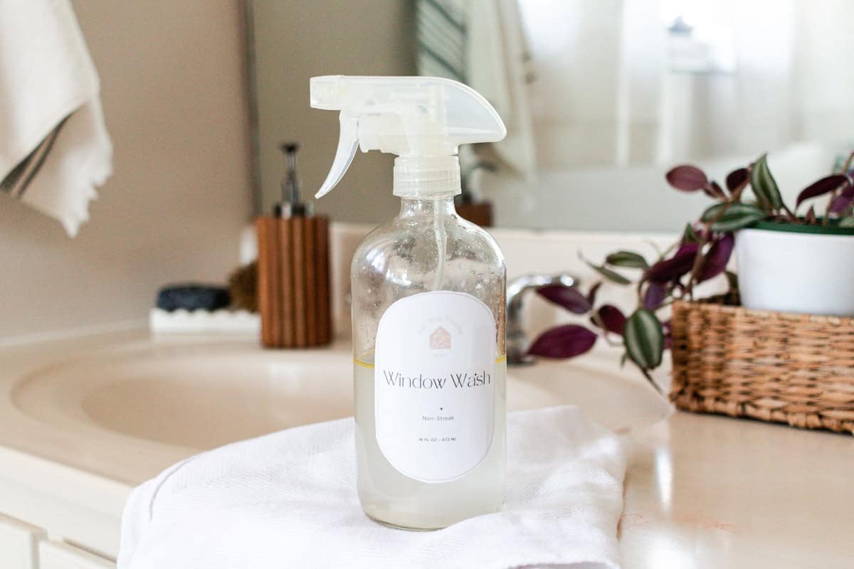 Homemade window cleaner sitting on a white marble vanity.