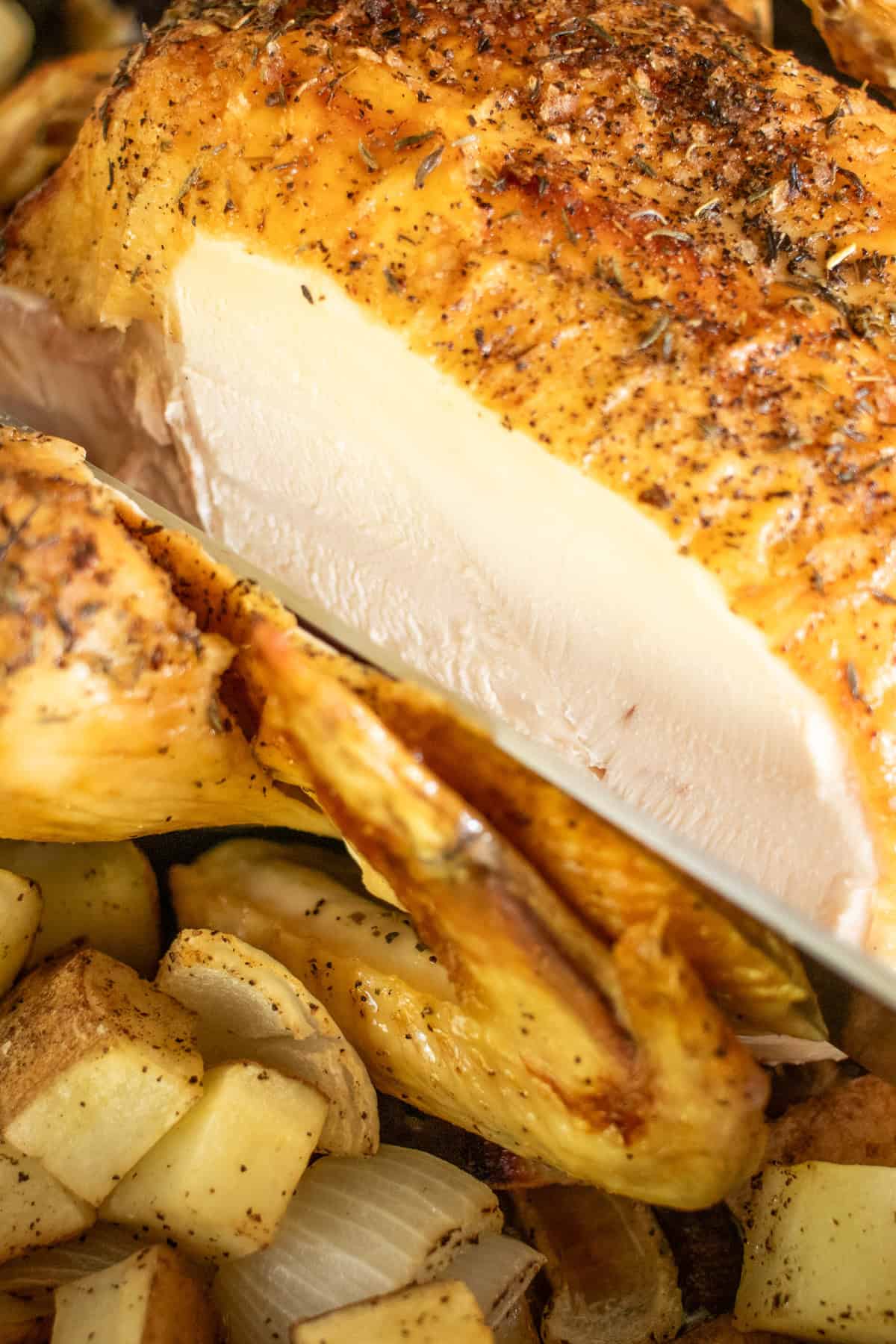 Roast chicken sliced, revealing succulent, moist chicken.