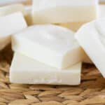 Tallow soap bars stacked up on a wicker placemat.