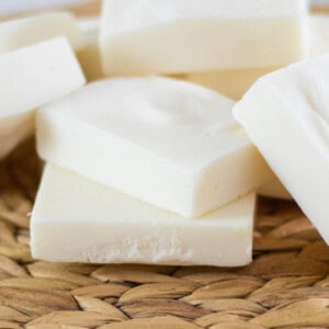 Tallow soap bars stacked up on a wicker placemat.