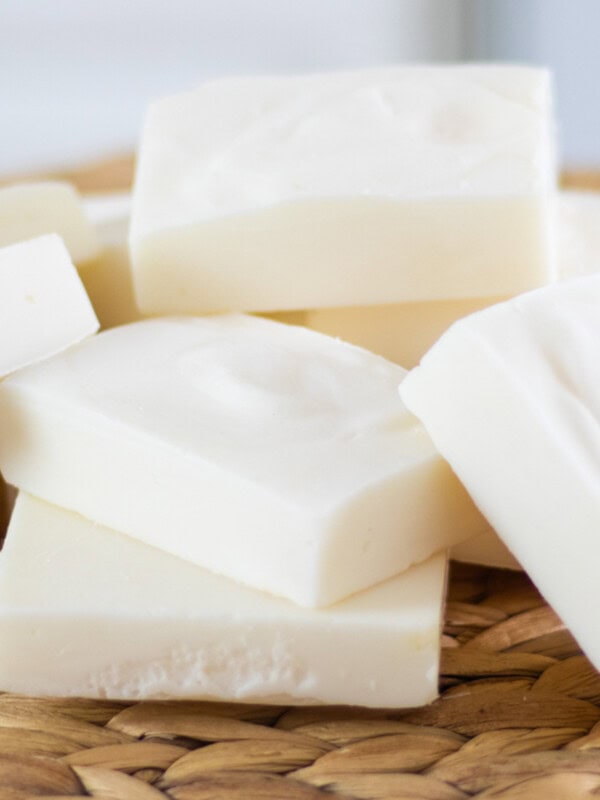 Tallow soap bars stacked up on a wicker placemat.
