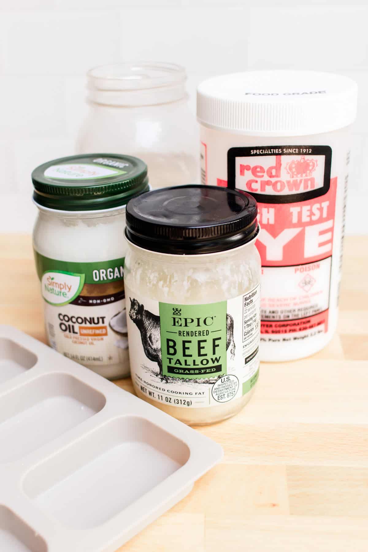 Tallow soap ingredients assembled on a wooden counter.