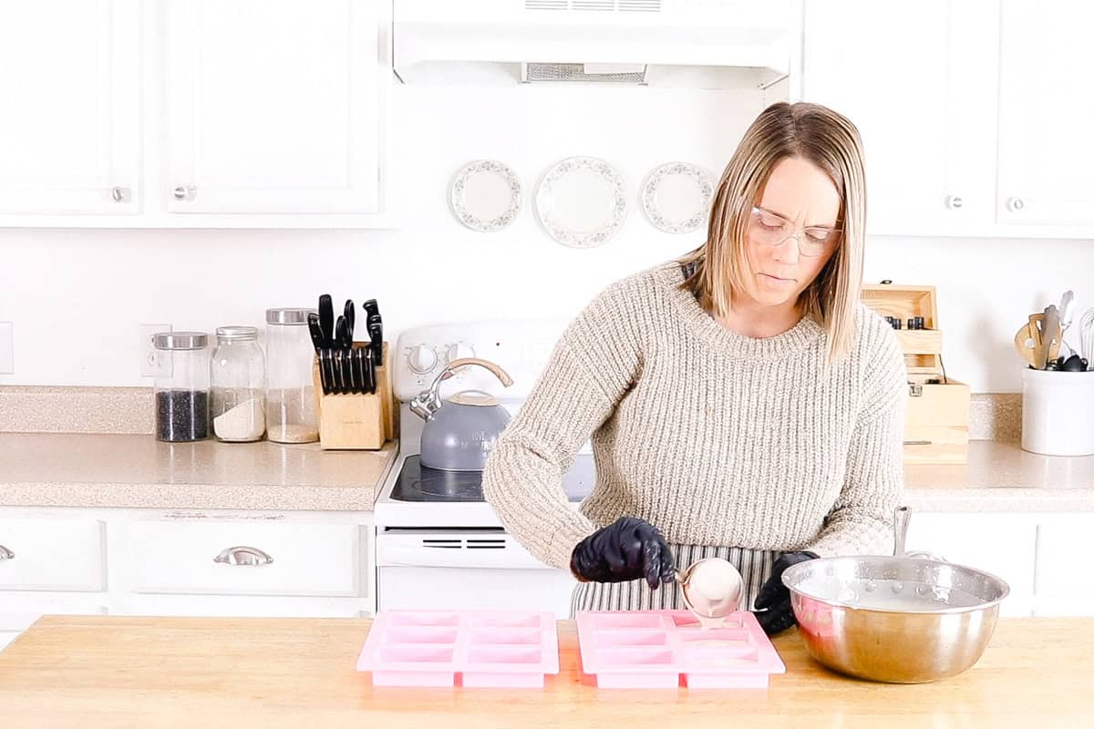 Scooping soap mixture into a silicone soap mold.