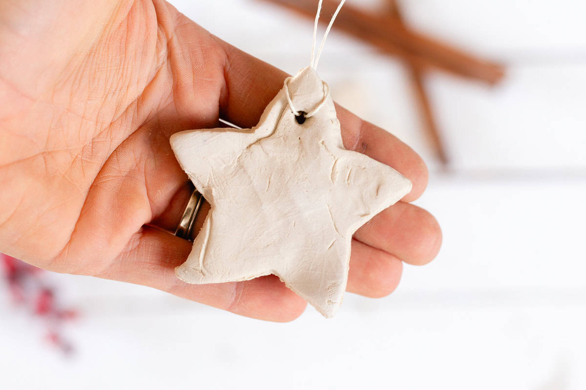 A hand holding a star-shaped diffuser ornament.