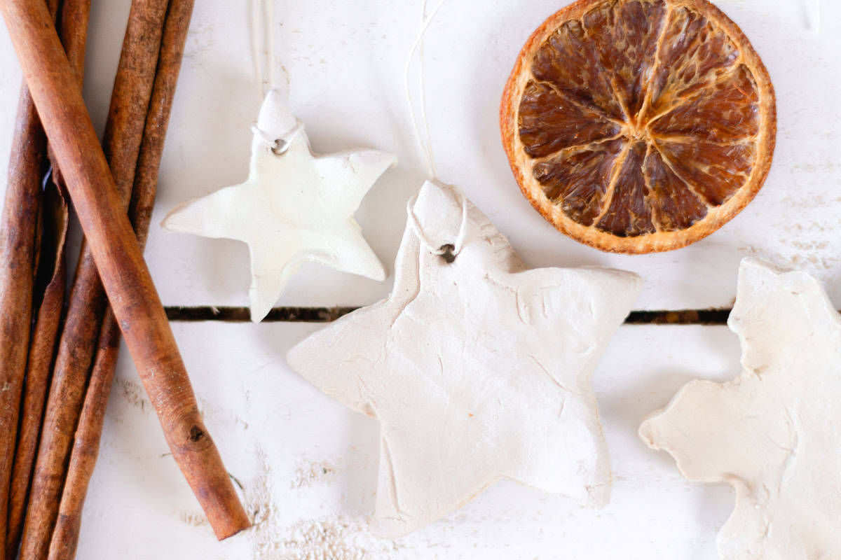 Three diffuser ornaments on a white backdrop with a dried orange and cinnamon sticks.