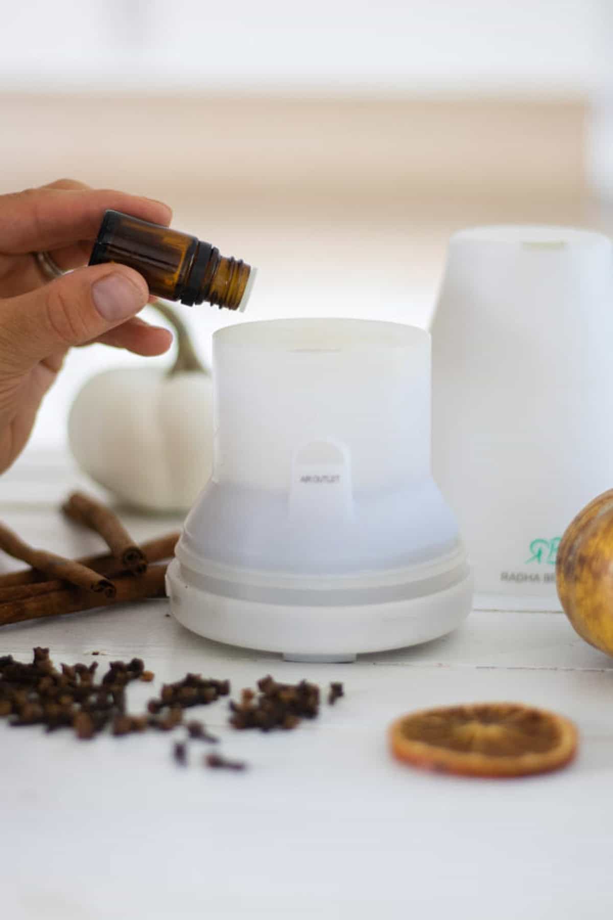 Dropping essential oils into a diffuser.