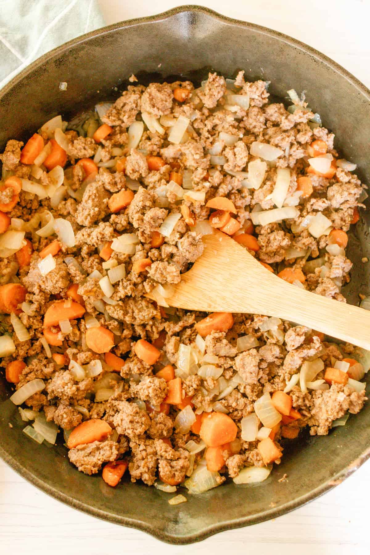 Cooking beef and carrots in a cast iron skillet.