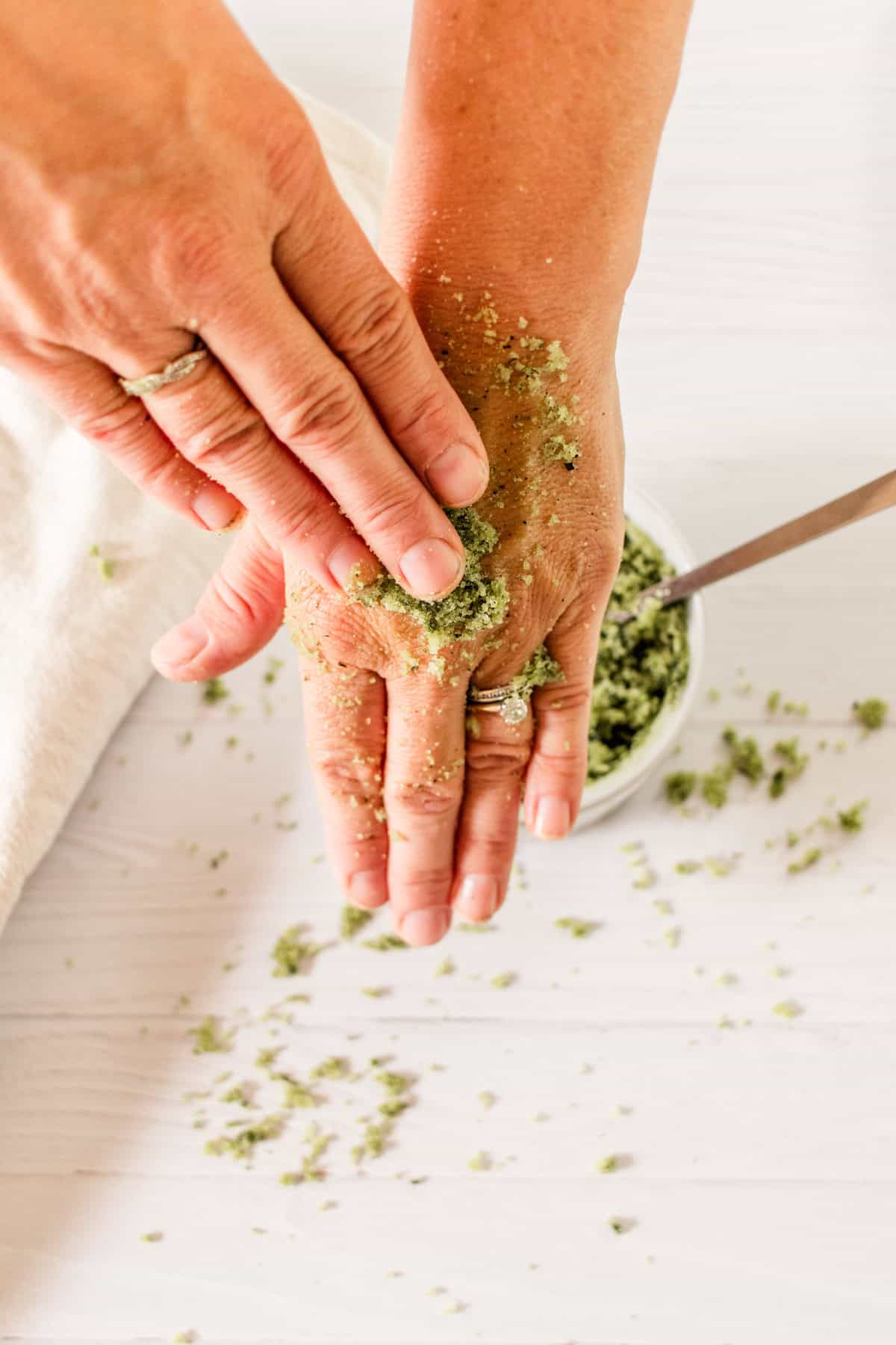 Scrubbing matcha green tea scrub into the hands.