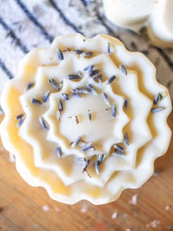 A flower-shaped bar of soap with dried lavender buds on it.