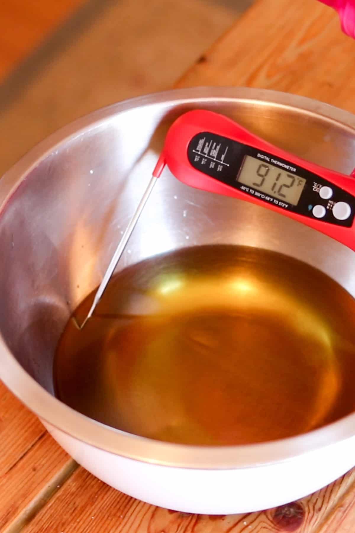 Checking the temperature of melted lard with a digital thermometer.