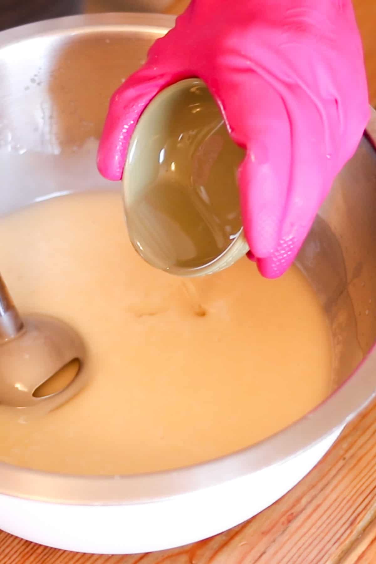 Adding essential oils to the soap mixture.