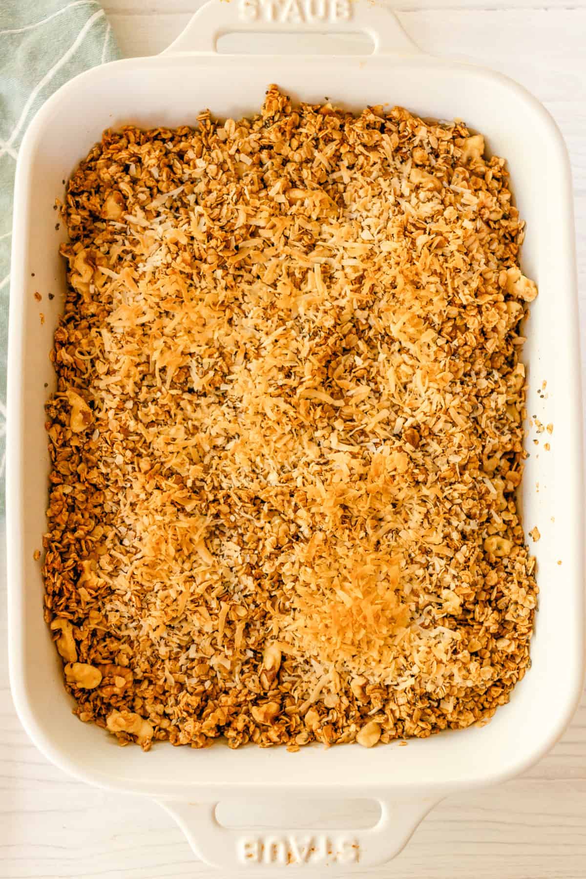 Granola with toasted coconut in a baking dish.