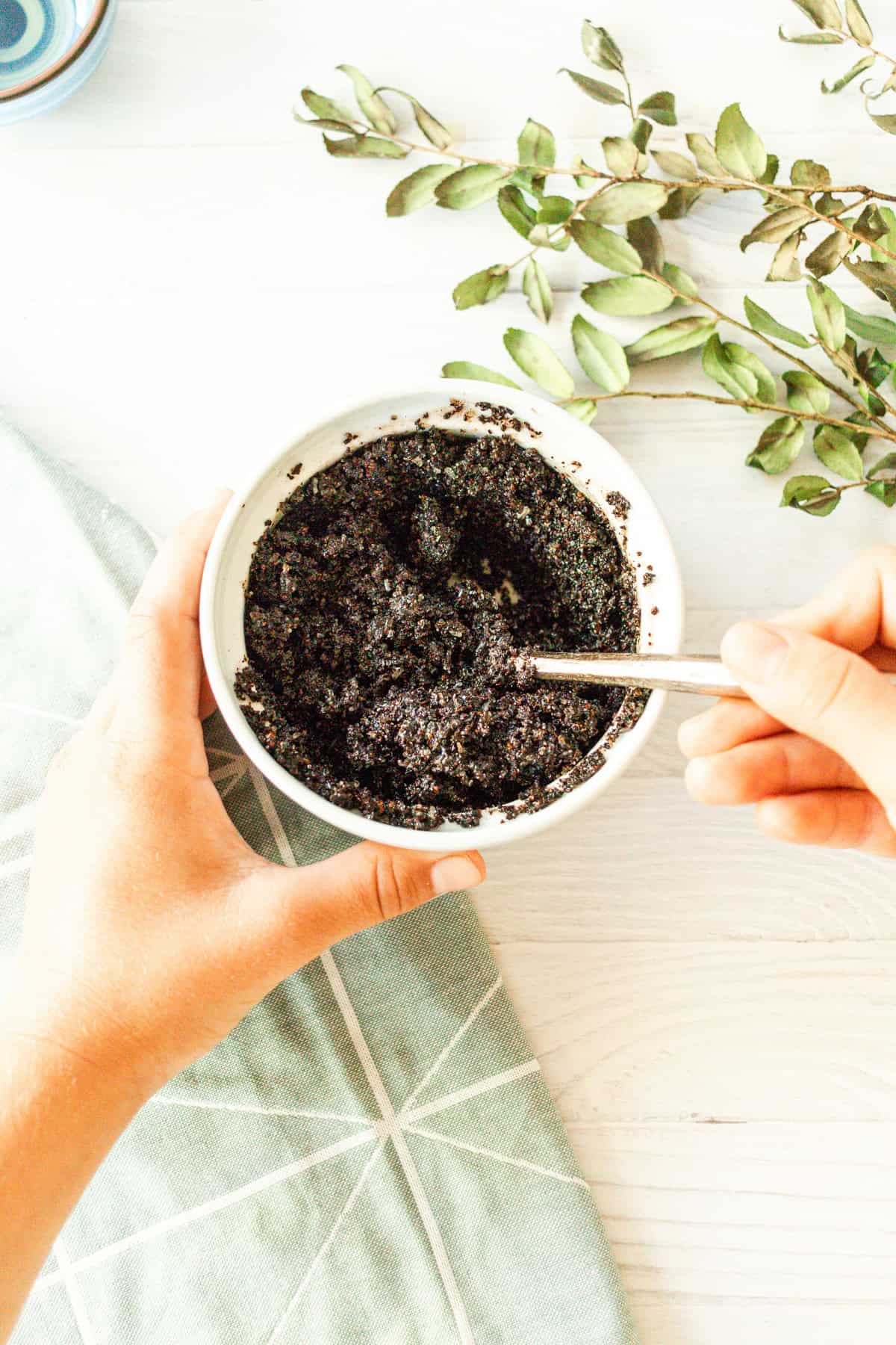 Mix the ingredients for the peppermint sugar scrub with a wooden spoon until well combined.