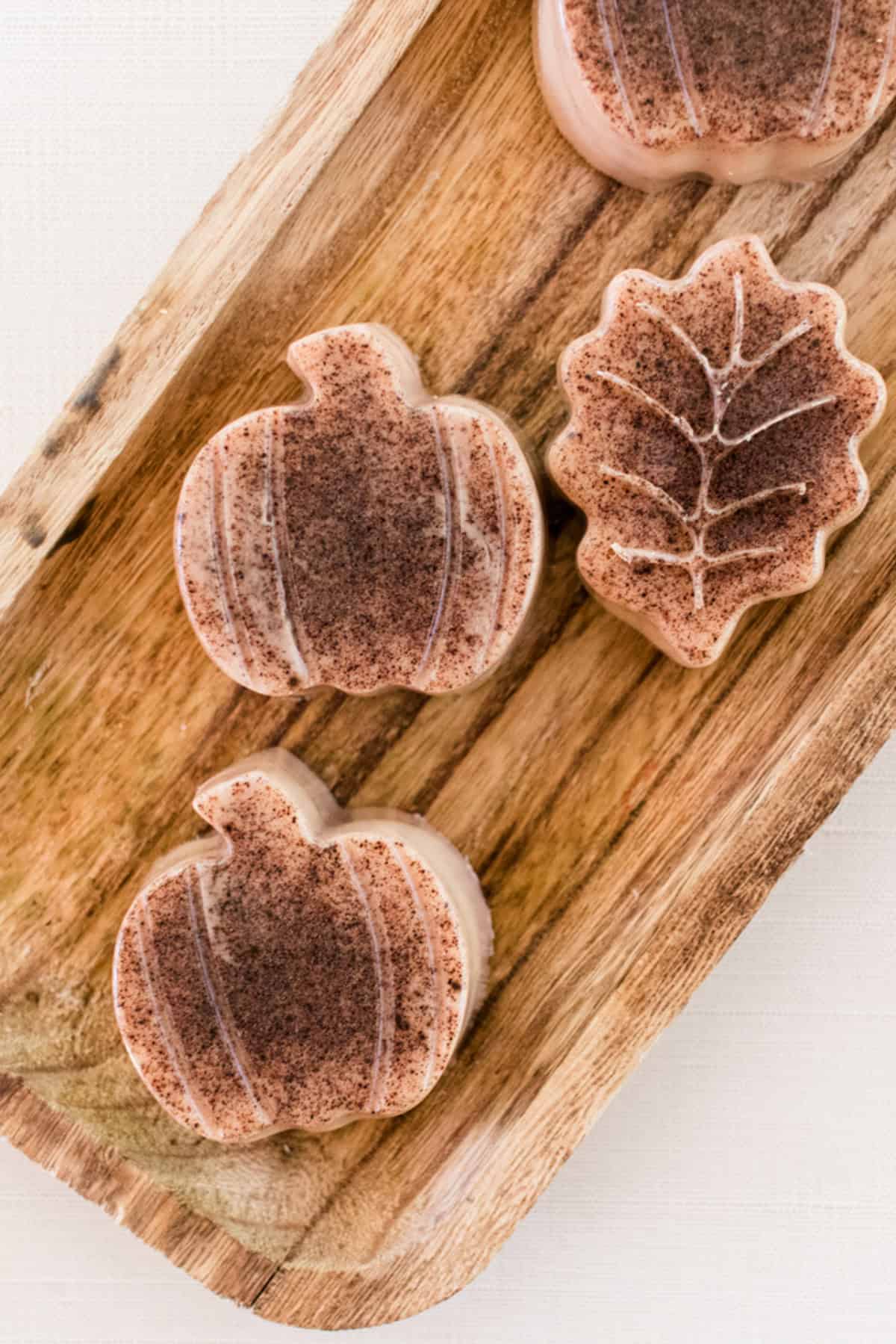 Pumpkin spice soap bars on a wooden tray.