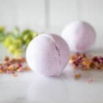 Two bath bombs on a counter with dried flowers.