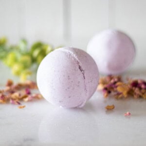 Two bath bombs on a counter with dried flowers.