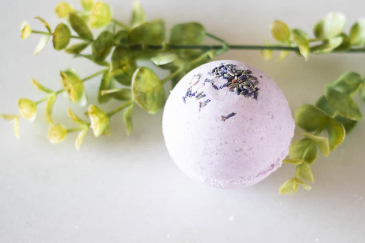 A purple bath bomb with greenery.