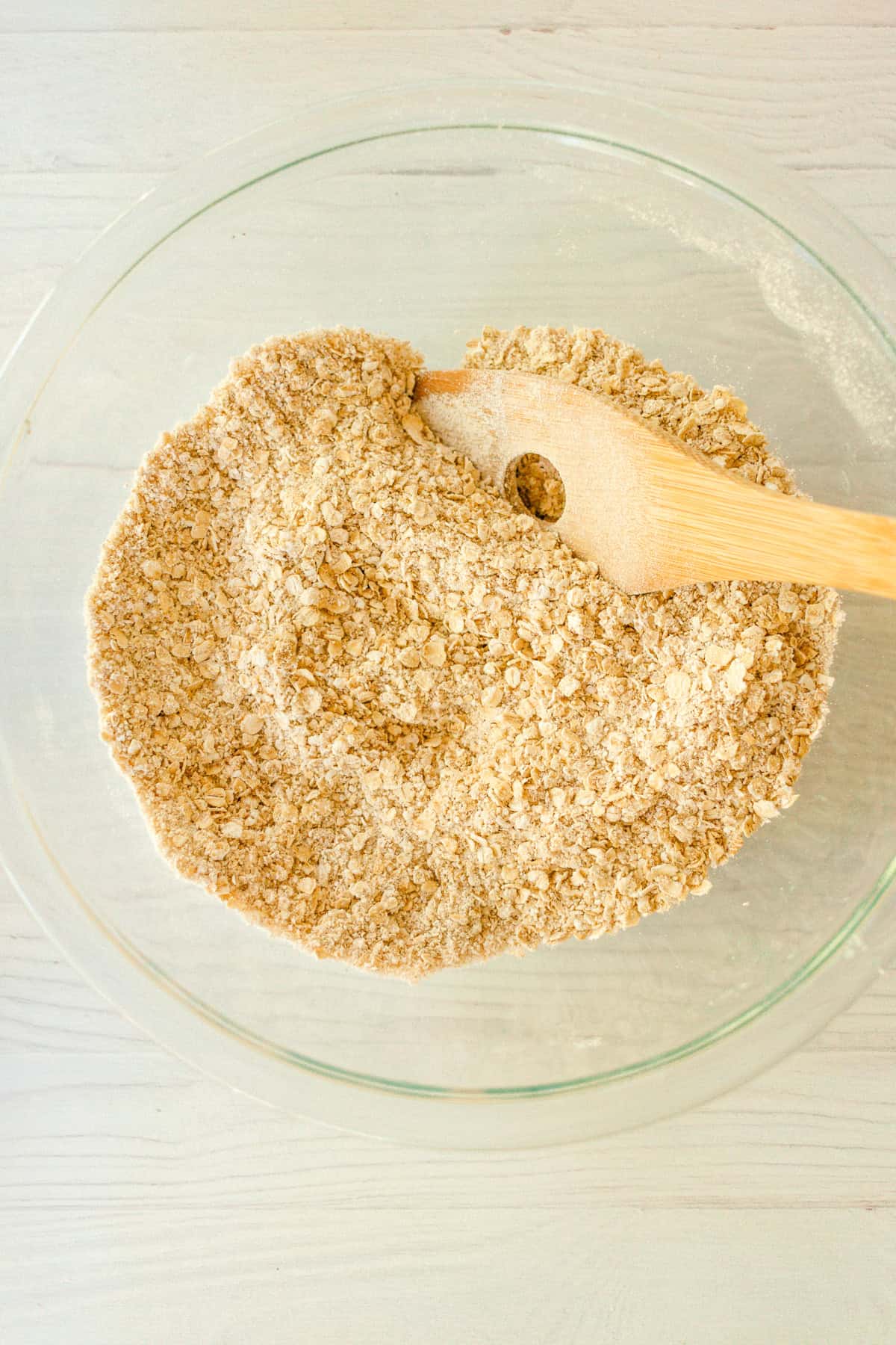 Whisking together the oat flour, oatmeal, monk fruit, baking powder, baking soda, and cinnamon in a medium-sized mixing bowl.
