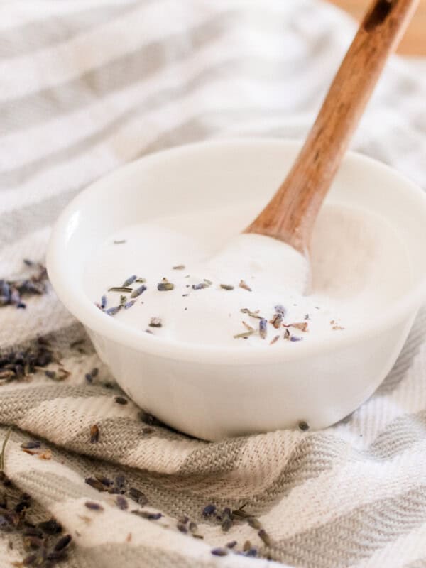 Diy clarifying hair shampoo paste with dried lavender being scooped with a wooden spoon.