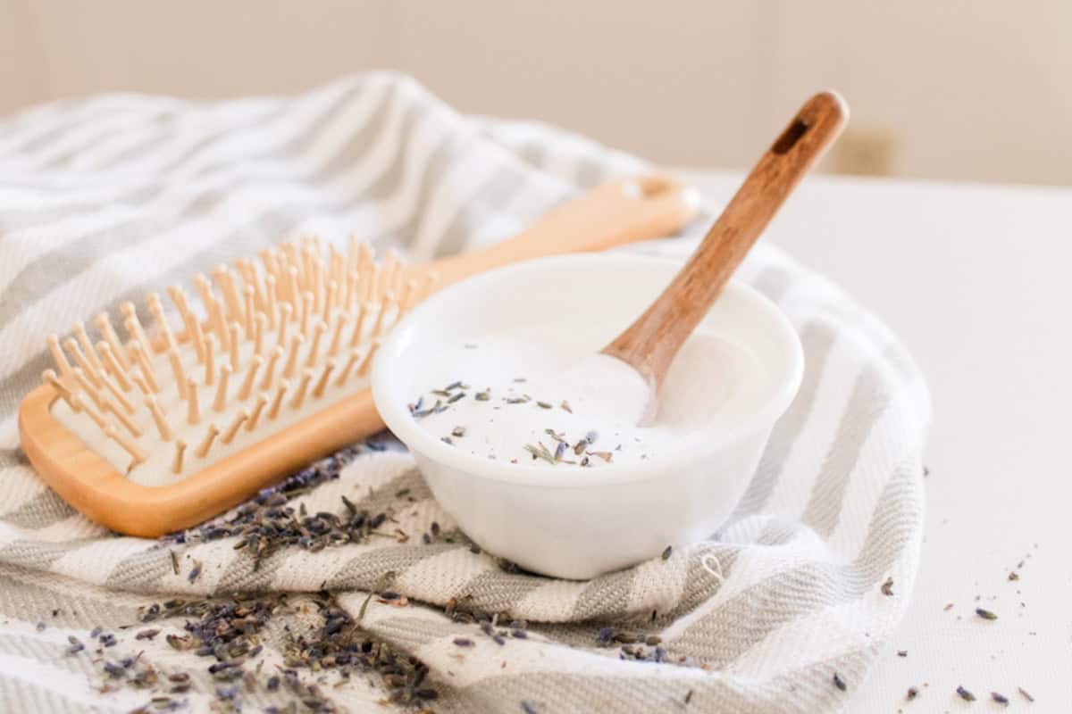 Small bowl of baking soda shampoo on a grey and white striped tea towel.