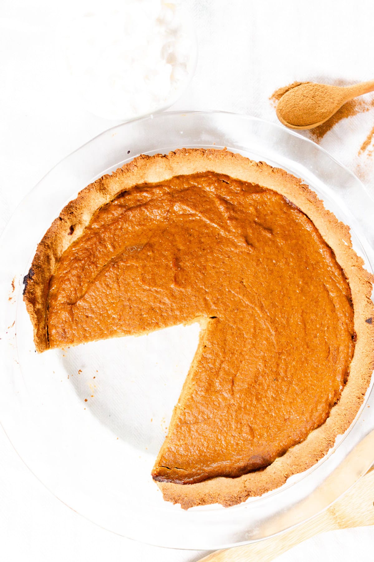 A healthy pumpkin pie with a slice taken out.