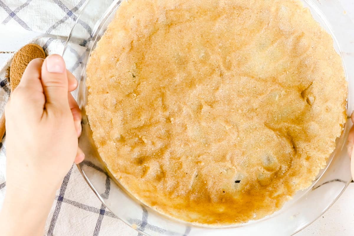 A homemade gluten-free crust in a pie pan.
