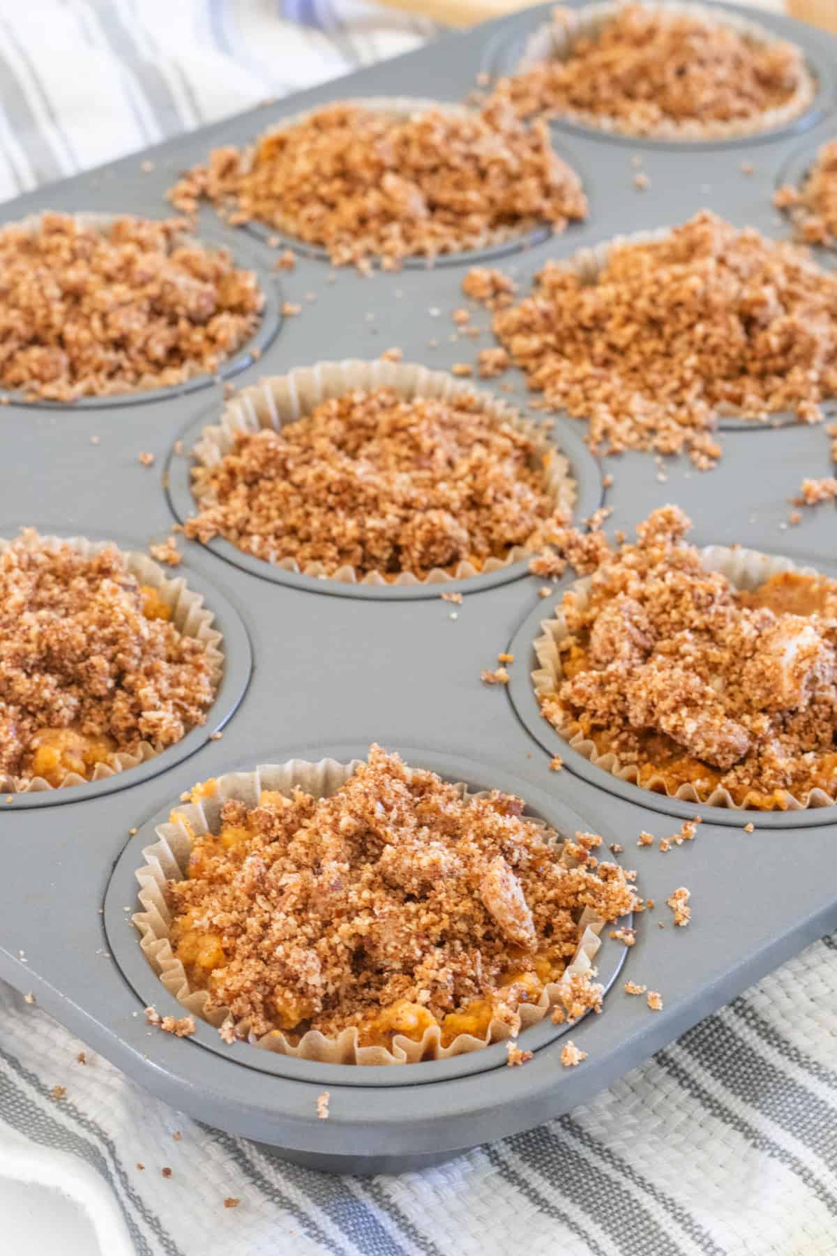 Pumpkin Crumble is spread on top of the muffins while they are still in the cookie tray.