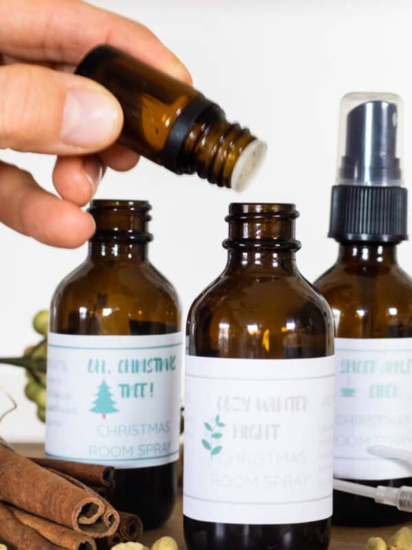 Dropping essential oils into a bottle to make holiday room spray.