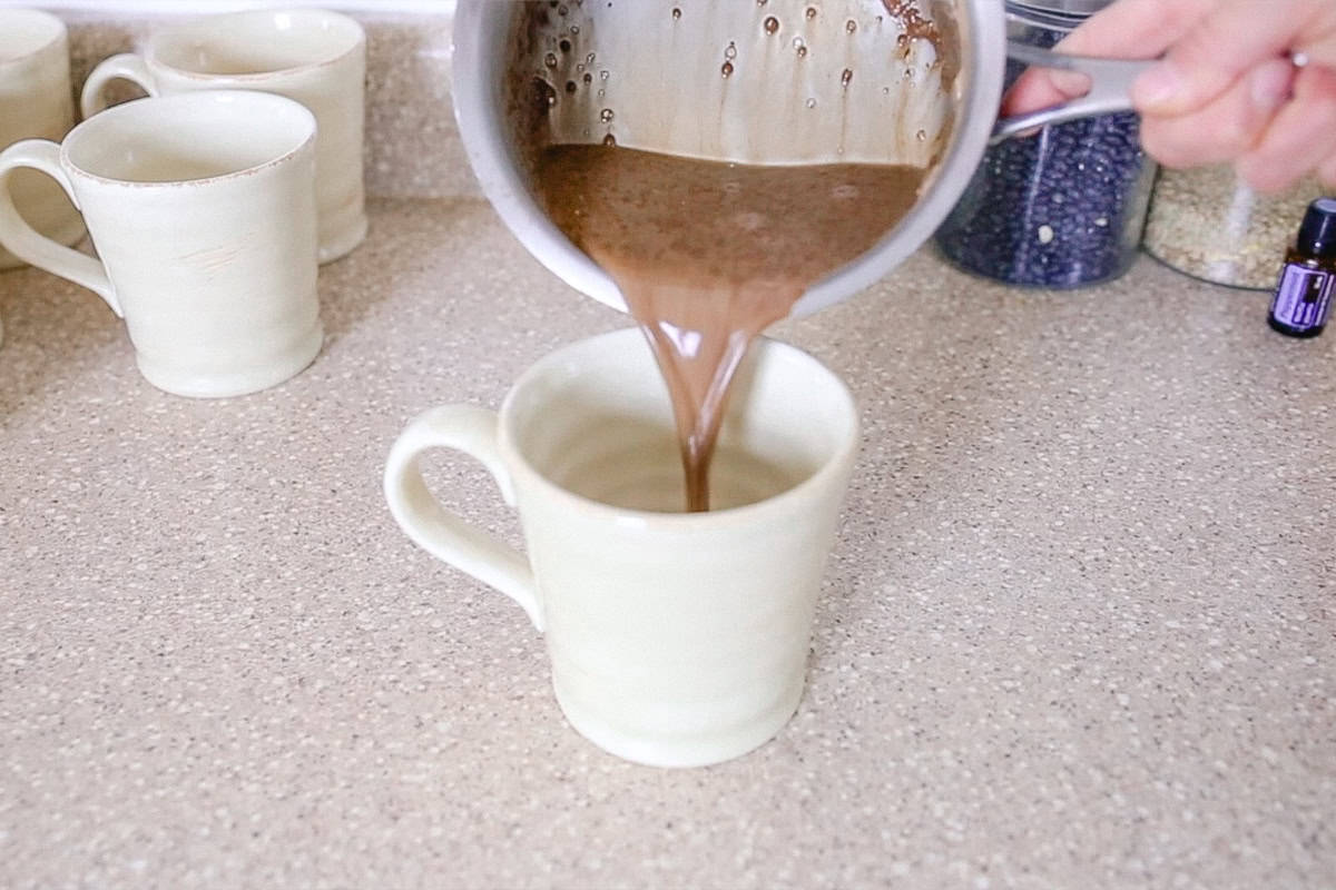 Pouring paleo hot cocoa from a pot to a mug.